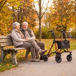 Älteres Paar auf der Parkbank neben dem Rollator Dietz TAiMA M