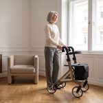 Dame mit dem Rollator Alevo Alu in Platin am Fenster ihrer Altbauwohnung