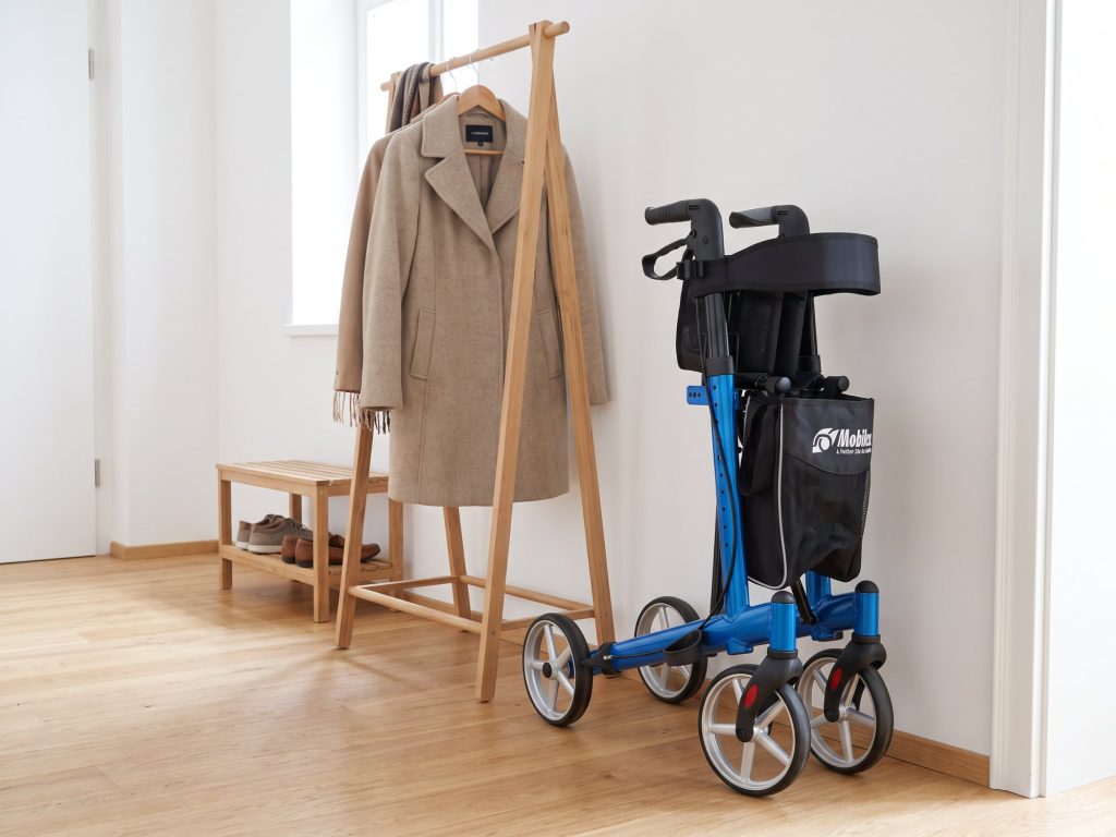 Gefalteter Rollator Mobilex Panther Small steht platzsparend neben der Garderobe im Vorzimmer
