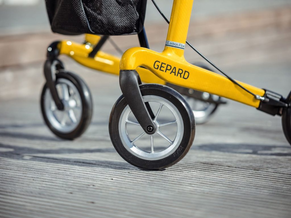 Nahaufnahme Carbon-Rollator Gepard – gelber Carbonrahmen mit Schriftzug und Softrad 200 mm