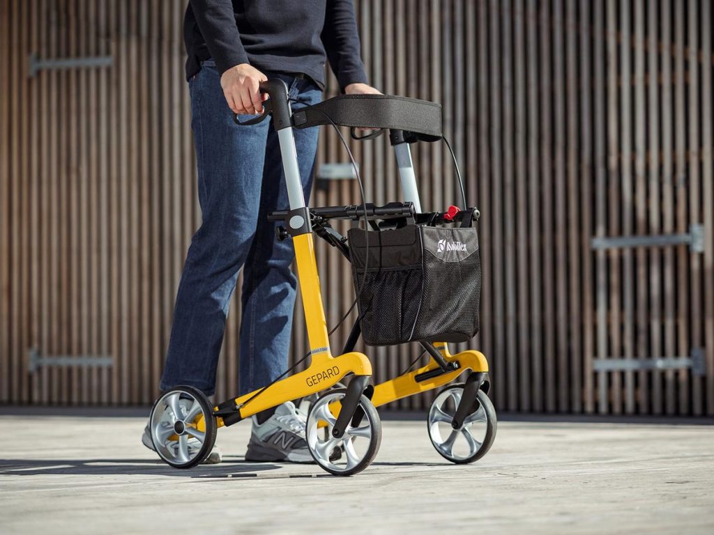Mann geht mit dem Carbon-Rollator Gepard – Griffe hoch eingestellt für große Menschen